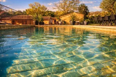 a swimming pool in front of a house at Studio cosy à Lagnes avec Piscine au milieu des oliviers in Lagnes