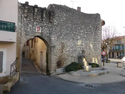 a stone building with a statue in front of it at La Reynière du Sud Luberon in La Bastide-des-Jourdans