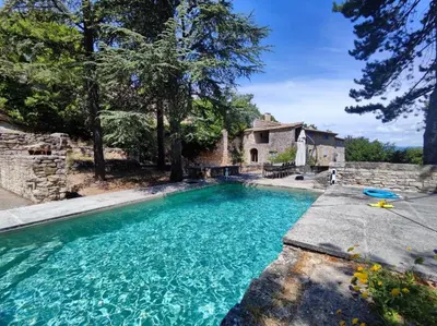 a swimming pool in front of a house at Les Grottes in Sivergues