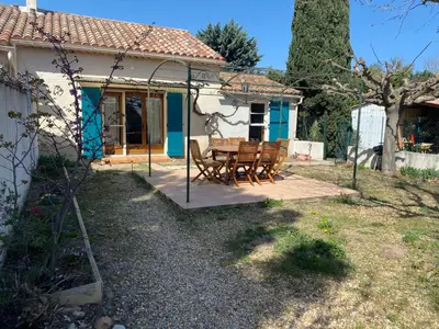 a patio with a table and chairs in front of a house at Gîte Lou Pastre in Aureille