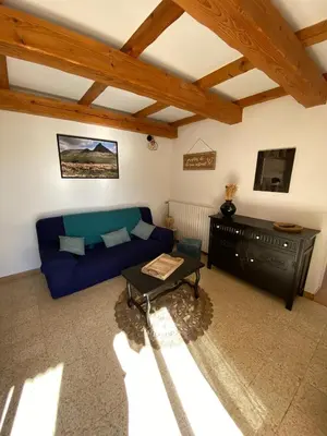 a living room with a blue couch and a table at Gîte Lou Pastre in Aureille