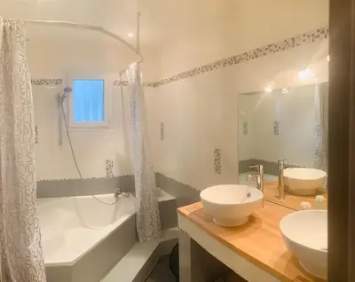 a bathroom with two sinks and a tub and a shower at Mas Moucia in Mormoiron
