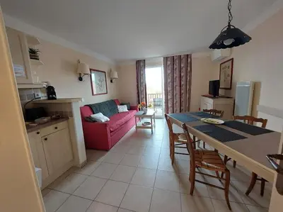 a kitchen and a living room with a pink couch at Maison 3 pièces domaine golf Pont Royal in Mallemort