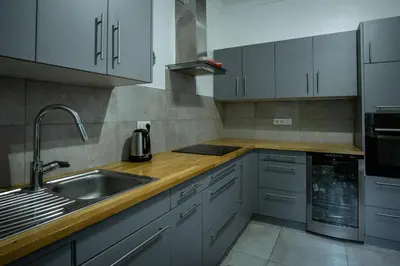 a kitchen with white cabinets and a sink at Le Mas de Jalique - Isle-sur-la-Sorgue in LʼIsle-sur-la-Sorgue