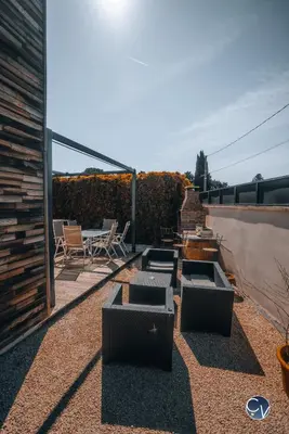 a patio with chairs and a table on a roof at Villa Moderne avec Jacuzzi proche d'Avignon in Le Thor