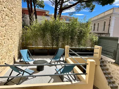 a patio with two chairs and a table on a balcony at La Maison de Lola in Carpentras