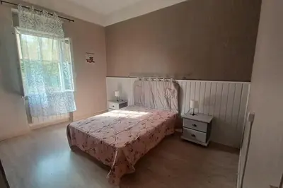 a bedroom with a bed with a pink bedspread and a window at maison 4 à 6 personnes proche village in Pélissanne