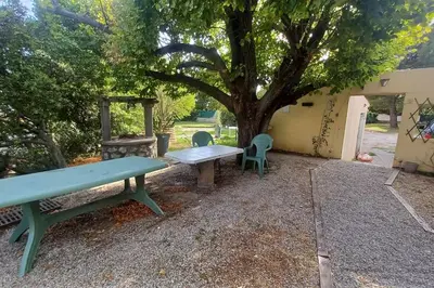 a picnic table and chairs sitting under a tree at maison 4 à 6 personnes proche village in Pélissanne