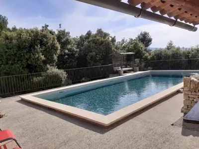 a swimming pool in the middle of a patio at Gîte Bienvenue Chez Nous in Ménerbes