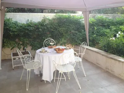 a white table and chairs on a patio at Chez Fleur in Avignon