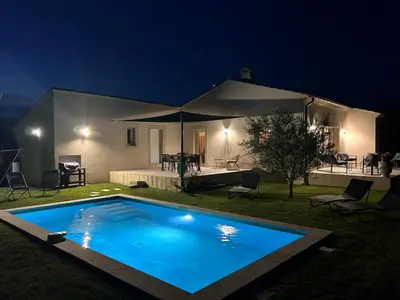 a swimming pool in front of a house at night at Moun Cabanoun in Carpentras