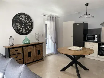 a kitchen with a table and a clock on the wall at Moun Cabanoun in Carpentras
