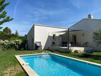 a villa with a swimming pool in front of a house at Moun Cabanoun in Carpentras