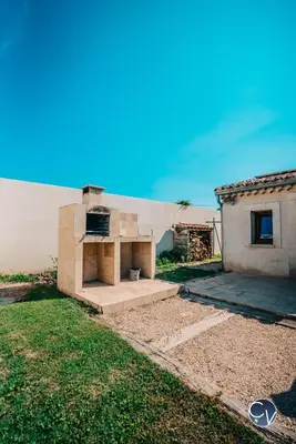a house with an outdoor oven in the yard at Villa le Thor Piscine Billard Sauna et Jacuzzi in Le Thor