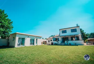 a white house with a yard in front of it at Villa le Thor Piscine Billard Sauna et Jacuzzi in Le Thor