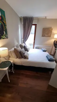 a bedroom with a large bed with a window at Centre d'Aix - charmant appartement 1 chambre Pythagore avec parking in Aix-en-Provence