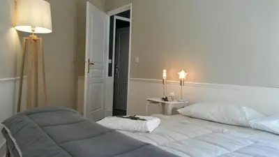 a bedroom with a large white bed and a lamp at Centre d'Aix - charmant appartement 1 chambre Pythagore avec parking in Aix-en-Provence