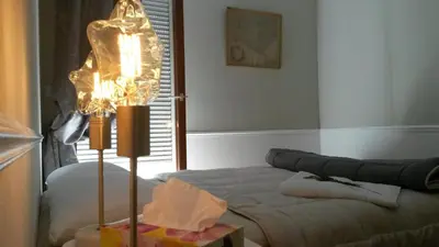 a room with a bed with a lamp and a table at Centre d'Aix - charmant appartement 1 chambre Pythagore avec parking in Aix-en-Provence
