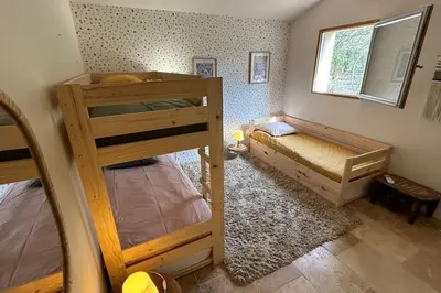a bedroom with two bunk beds and a window at La Terrasse Collongue in Lourmarin