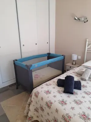 a bedroom with a bed with a blue crib at Villa le Bosquet en Luberon. in Ménerbes