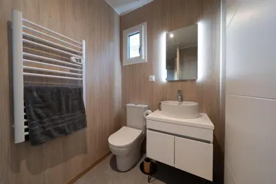 a bathroom with a toilet and a sink and a mirror at Le Chant des Pins Lodge & Spa Massif de l'Etoile in Saint-Marc-Jaumegarde