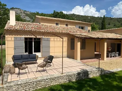 a patio with a couch and chairs in front of a house at Chante Coucou in Saint-Saturnin-les-Apt