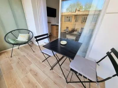 a black table and chairs in a room with a window at Les studios d'Aurélia - Grand Théâtre de Provence in Aix-en-Provence