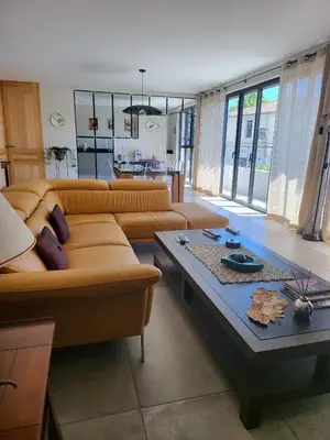 a living room with a couch and a table at Appartement standing bord Sorgue in LʼIsle-sur-la-Sorgue