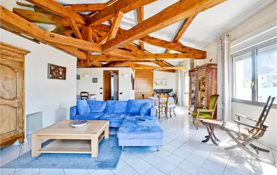 a living room with a blue couch and a table at 2 Bedroom Amazing Home In Châteaurenard in Châteaurenard