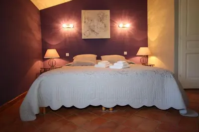 a bedroom with a large white bed with two lamps at Bastide Magnolia - Gite et chambres d 'hôtes Les dépendances, Roussillon in Roussillon