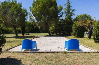 two blue chairs sitting in the sand in a park at Chambre d'hôtes - B&B - Grand Luberon chez Manon en Luberon in Lagnes