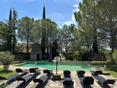 a swimming pool with lounge chairs in a yard at La Meynardière in Saint-Pierre-de-Vassols