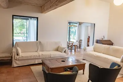 a living room with two couches and a coffee table at Le chant des jardins in LʼIsle-sur-la-Sorgue