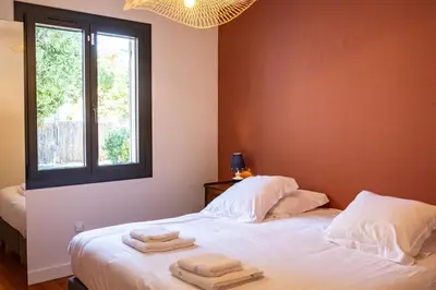a bedroom with a bed with towels on it at Le chant des jardins in LʼIsle-sur-la-Sorgue