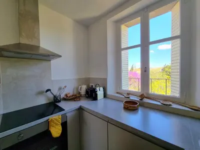 a kitchen with a counter top with a window at Appartement spacieux de standing - parking gratuit in Aix-en-Provence