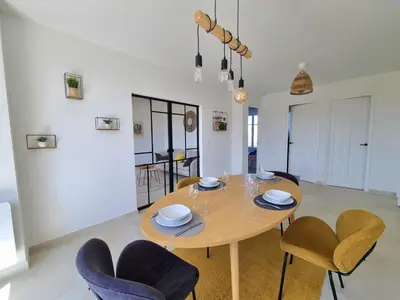 a dining room with a wooden table and chairs at Appartement spacieux de standing - parking gratuit in Aix-en-Provence