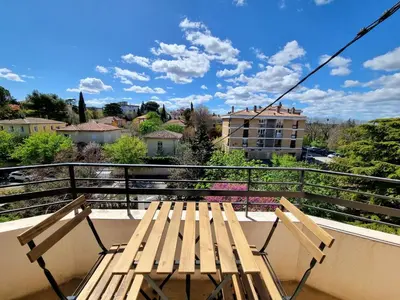 a table and chairs on a balcony with a view at Appartement spacieux de standing - parking gratuit in Aix-en-Provence