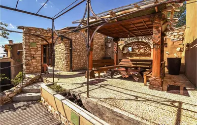 a patio with a wooden bench and a building at Gorgeous Home In Sault in Sault-de-Vaucluse