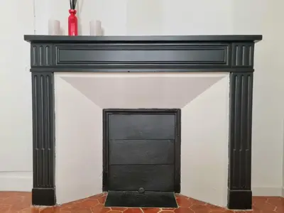 a fireplace with a black mantel on top of it at Studio centre historique 1 in Aix-en-Provence