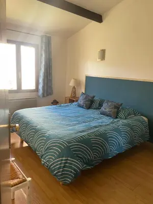 a bedroom with a large bed with a blue blanket at Jolie petite maison Avignon - Montfavet in Montfavet
